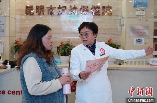 图为11月20日，昆明市妇幼保健院医生向民众介绍“新生儿出生即参保”情况。刘冉阳 摄