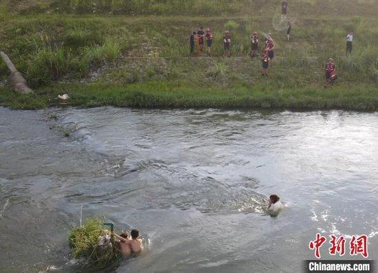 图为3名小孩被困河中。周勉摄