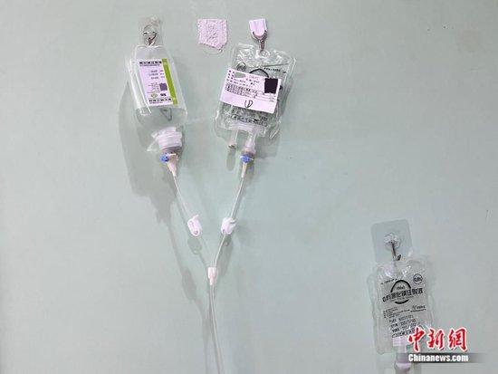 北京儿童医院门诊大楼，家长们在墙壁上贴上挂钩，用来悬挂输液袋。邵萌 摄