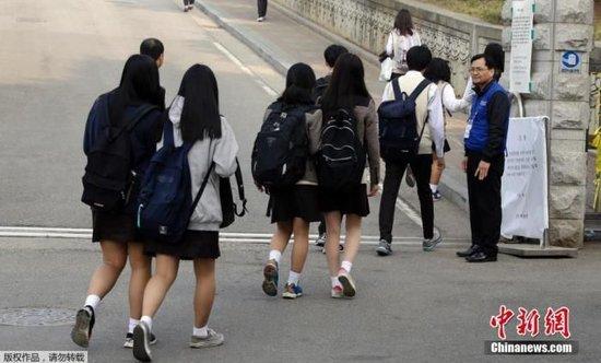 资料图：韩国学生准备进入校园上课。