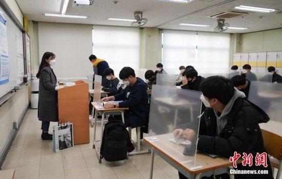 资料图：2020年12月3日，延迟近一个月的韩国高考举行。据韩国教育部消息，今年考生约49.34万人，创历史最低纪录。图为在首尔某考点内，考桌上设有隔板。 中新社发 首尔市教育厅 供图