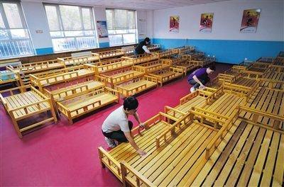 京师实验小学，幼儿园教师在对睡眠室的床铺进行清理。