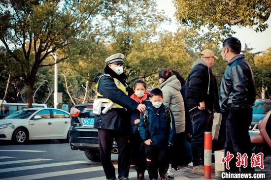 青浦区实验小学东校区门前的人流车流接连不断，但是在民警的的有序指挥下并不显得拥堵。上海市公安局青浦分局供图