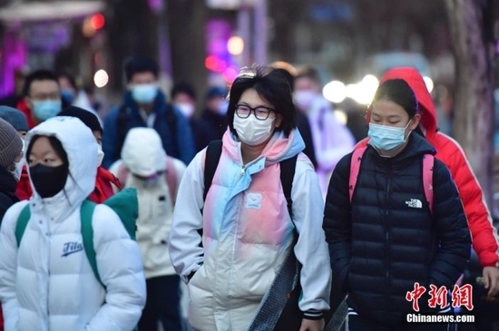 2月13日，北京中小学学生迎来开学日，中学生前往校园。中新社记者 田雨昊 摄