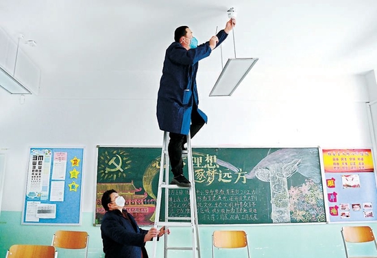昨天，北京市第十一中学西校区，维修人员在教室内检修护眼灯，为即将到来的新学期做准备。本报记者 和冠欣摄