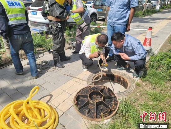 图为检测下水道空气质量，为工作人员搜救做准备。阿琳娜 摄