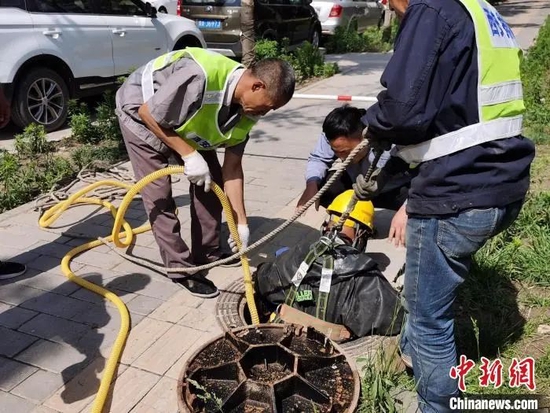 图为搜救人员在事发地附近的下水道进行搜救。党田野 摄